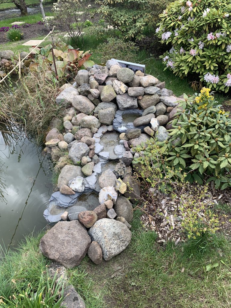Fertig gestellter Bachlauf (oben im Bild: Hinter Steinen versteckt das Solarpanel, welches die Bachlauf-Pumpe antreibt)