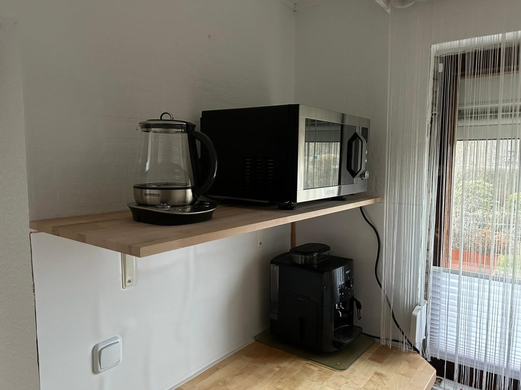 Wasserkocher und Mikrowellengrill oben, Kochfeld und Kaffeeautomat unten